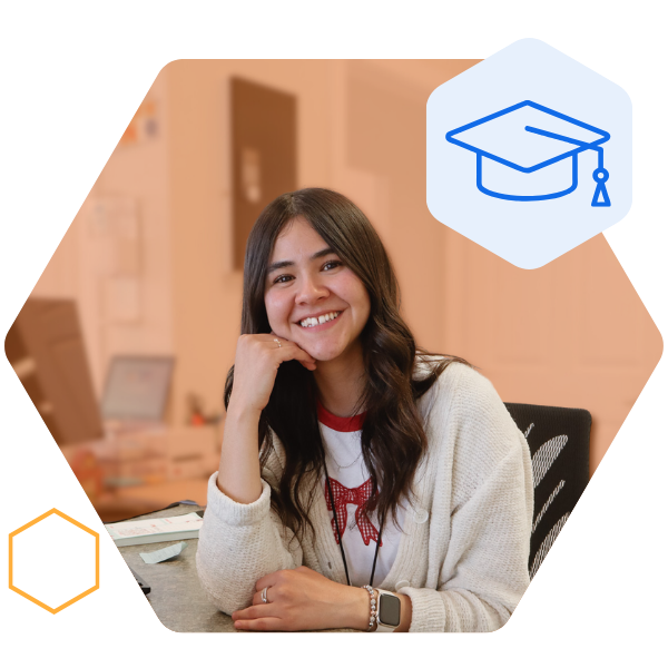 Staff sitting at a desk on campus smiling